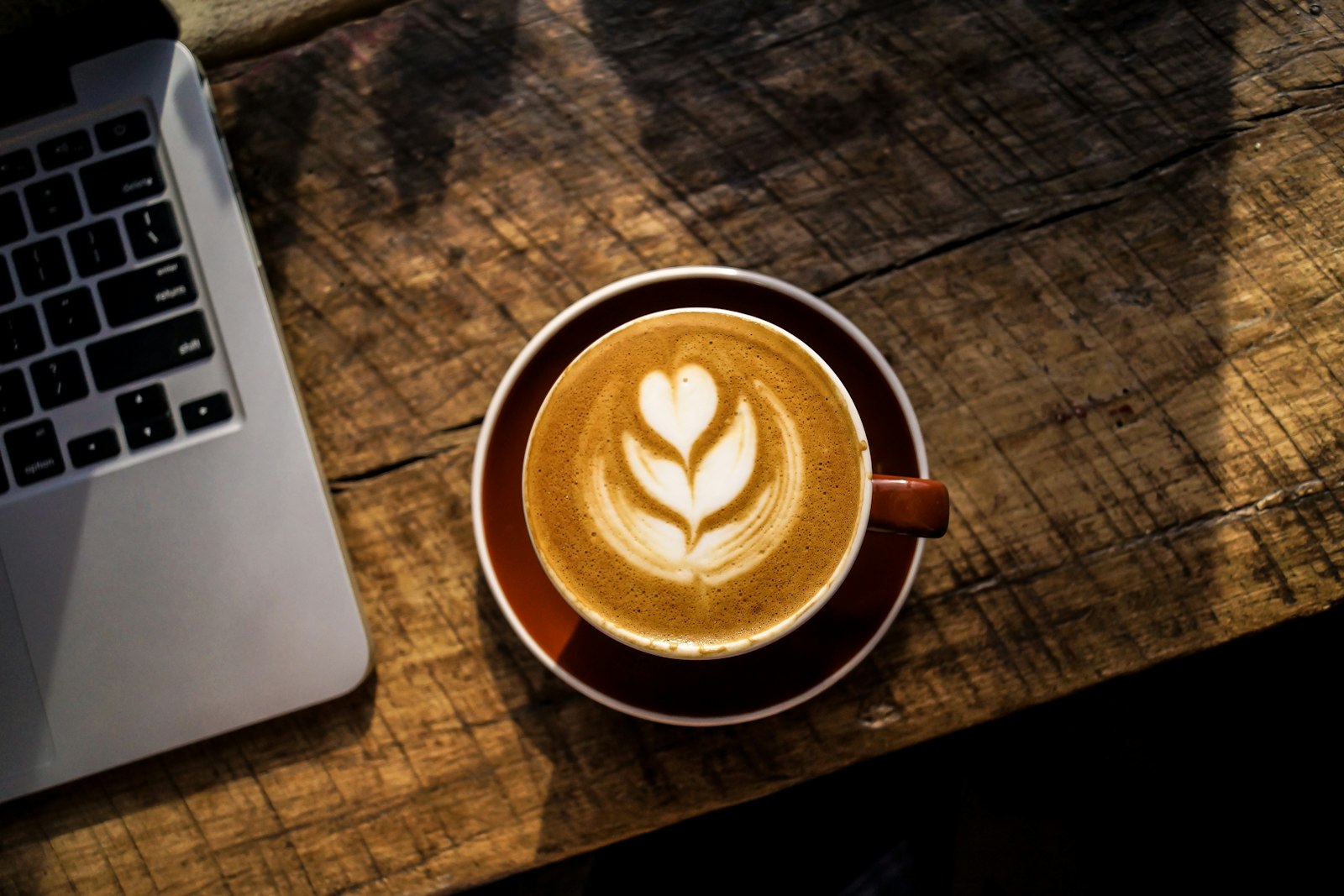 Home office com laptop e café, representando rotina de trabalho remoto